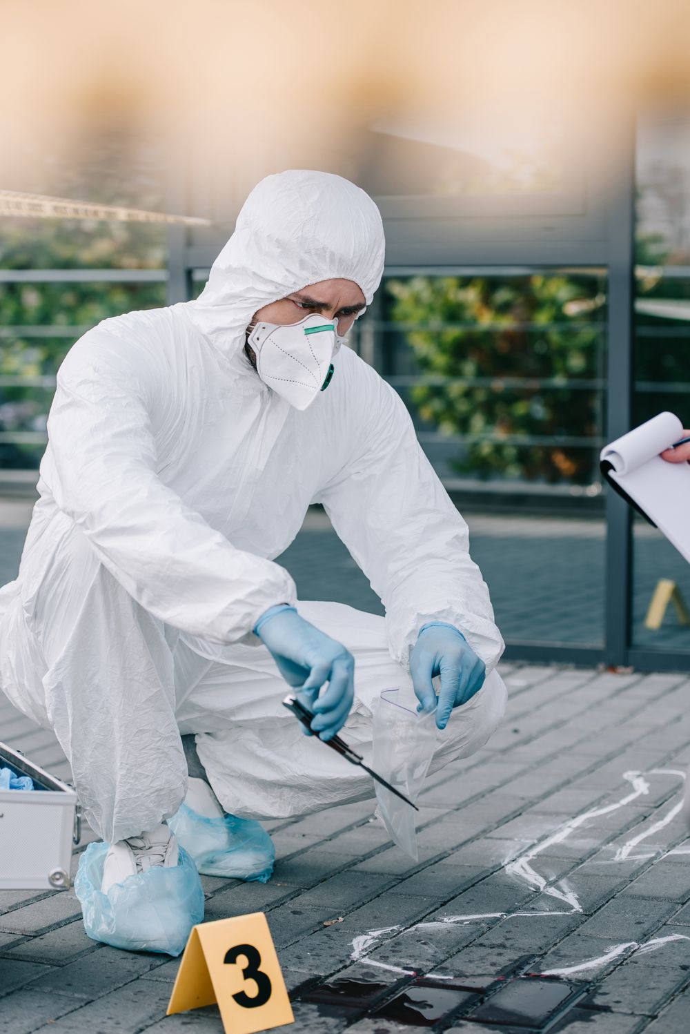 Onderzoeker in beschermende kleding onderzoekt bewijsmateriaal op een plaats delict